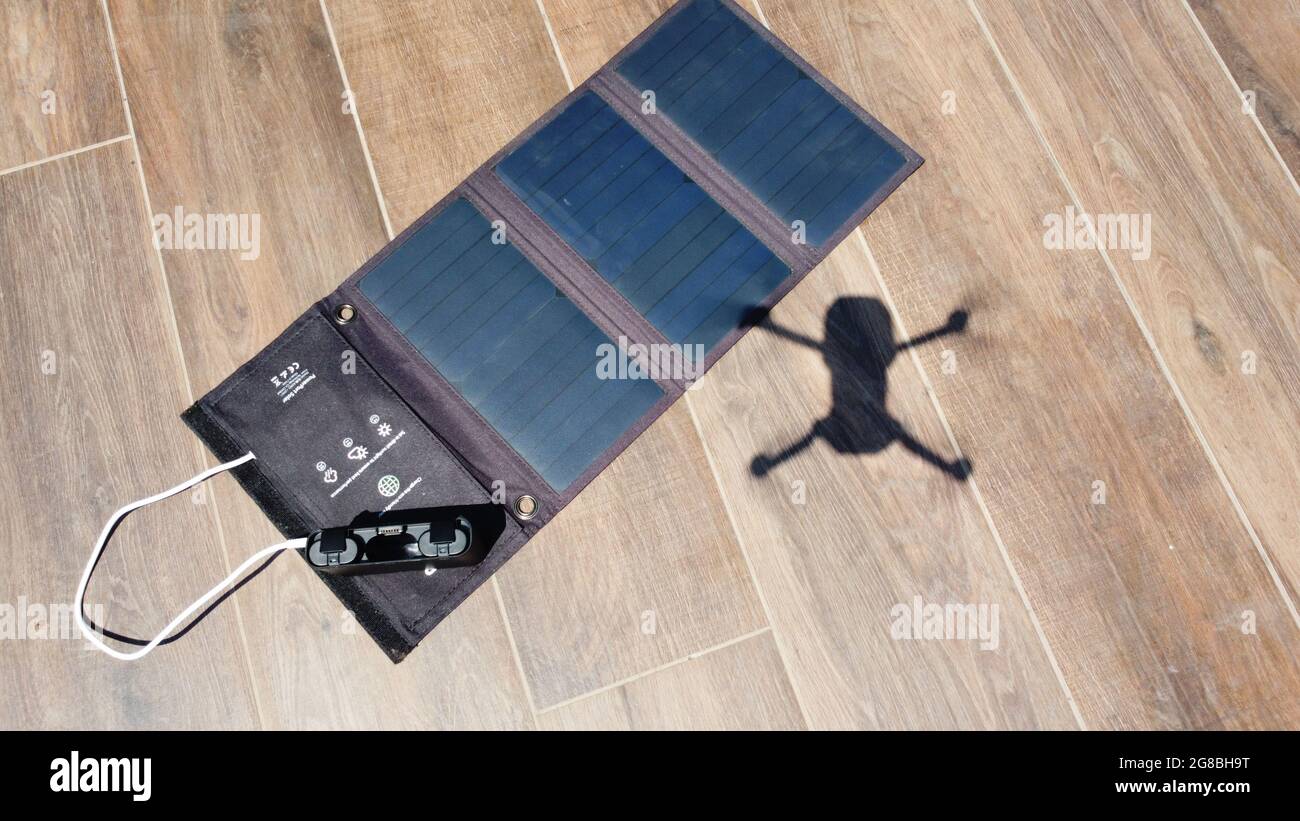 Drone che vola con energia rinnovabile grazie alle celle solari portatili. Drone vola senza emissioni sopra un pannello solare pieghevole, solo l'ombra può essere Foto Stock