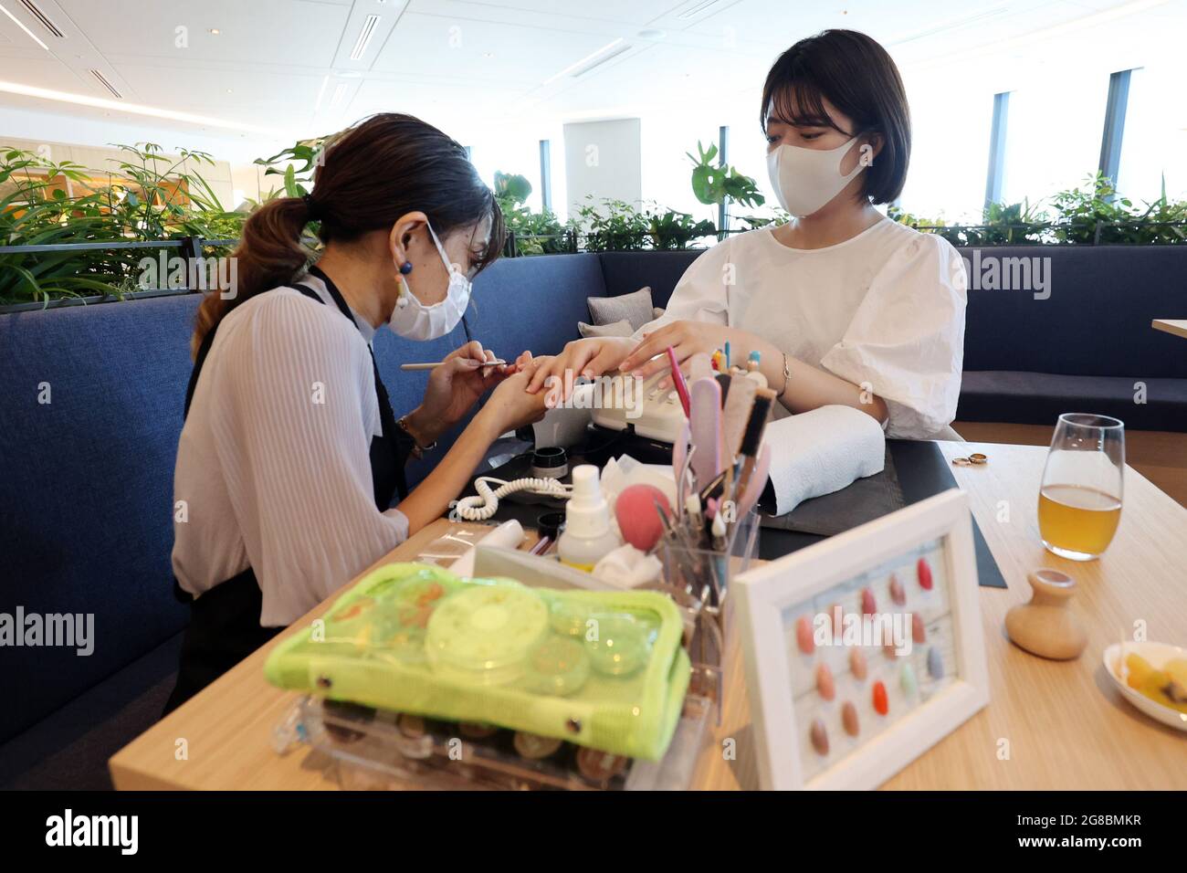 Tokyo, Giappone. 19 luglio 2021. Un'artista di unghie (L) lucida le unghie di un lavoratore di ufficio per una dimostrazione in un piano rilassante del nuovo edificio di 38 piani 'Tokyo Torch Tokiwabashi Tower' in un'anteprima stampa a Tokyo lunedì 19 luglio 2021. Mitsubishi Estate ha in programma di costruire un'altra torre nel 2027 presso lo stesso complesso che diventerà l'edificio più alto del Giappone. Credit: Yoshio Tsunoda/AFLO/Alamy Live News Foto Stock