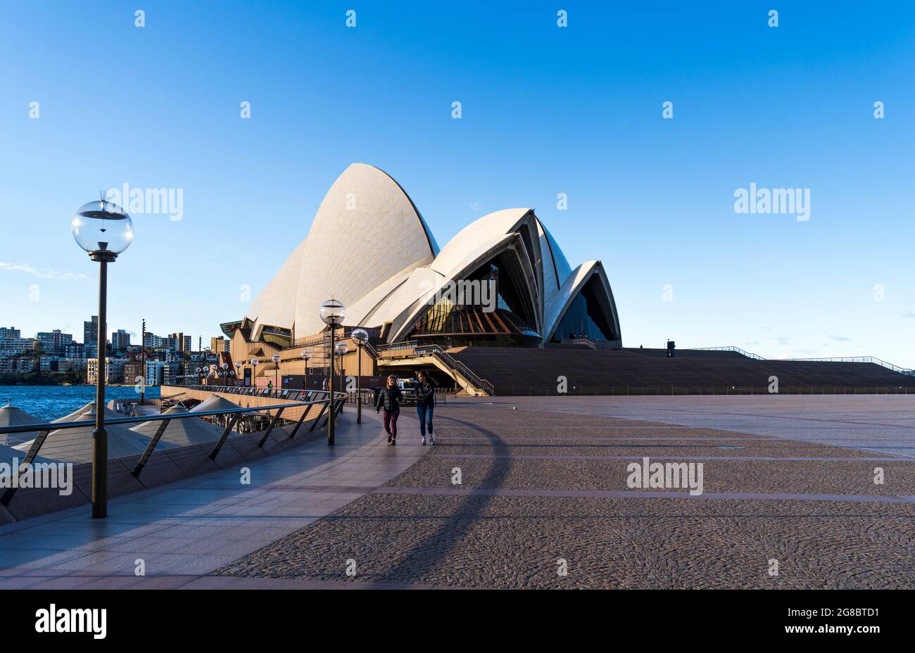 Teatro dell'Opera di Sydney con piazzale disertato e ristoranti vuoti. Giorno di sole blu luminoso Foto Stock