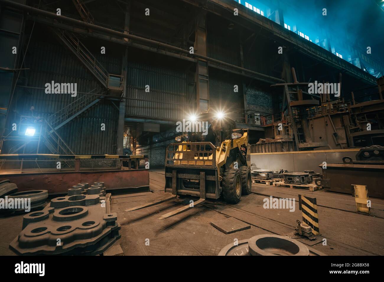 Trattore o falciatrice di piccole dimensioni sul lavoro in officina di fabbrica metallurgica. Foto Stock
