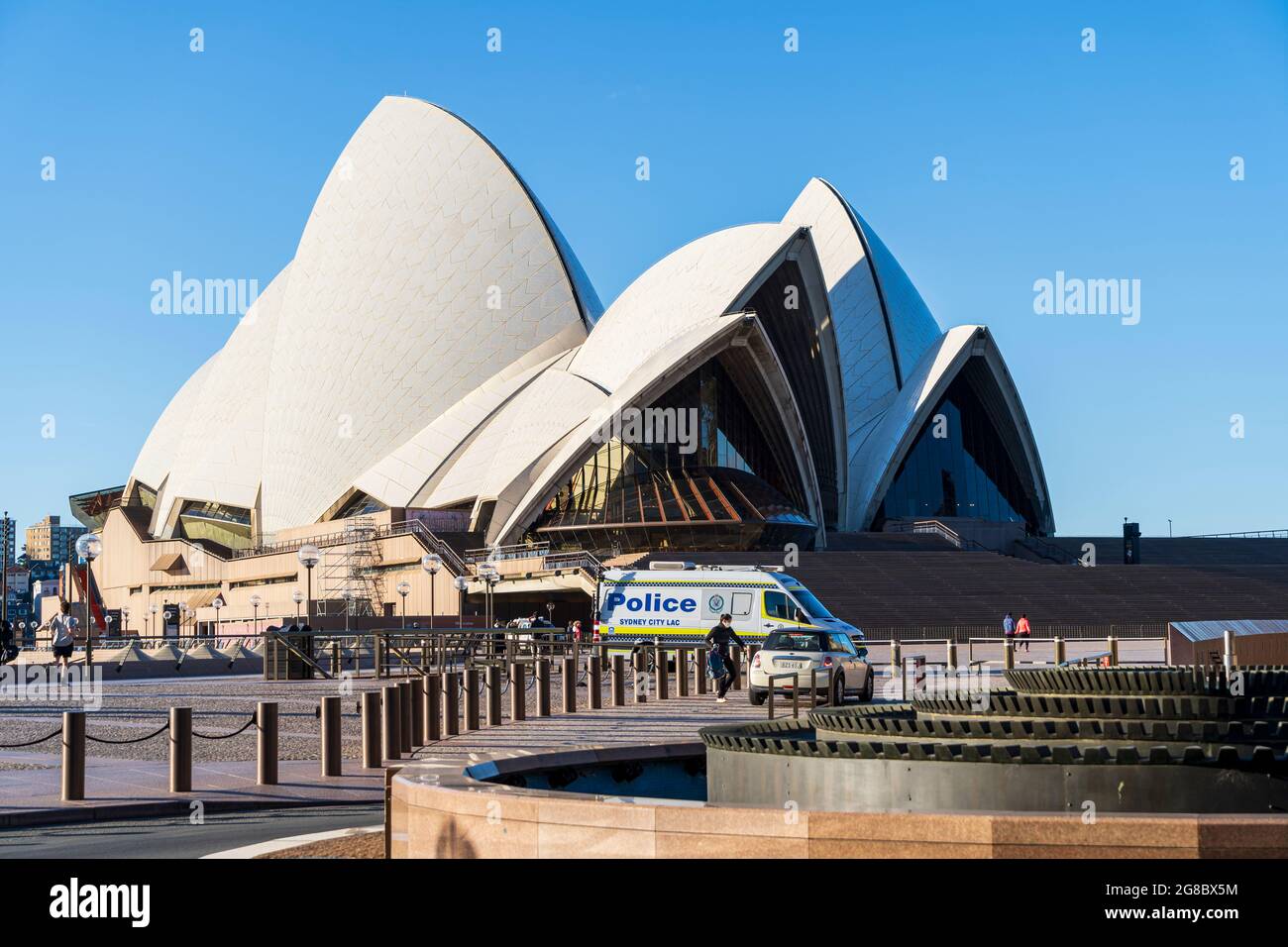 Teatro dell'Opera di Sydney con piazzale disertato e ristoranti vuoti. Giorno di sole blu luminoso Foto Stock