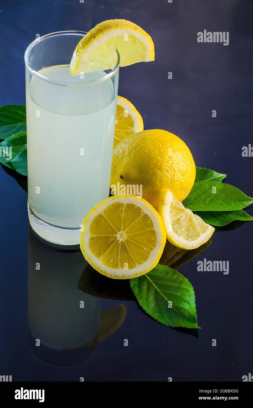 succo di limone fresco e limone su sfondo scuro Foto Stock