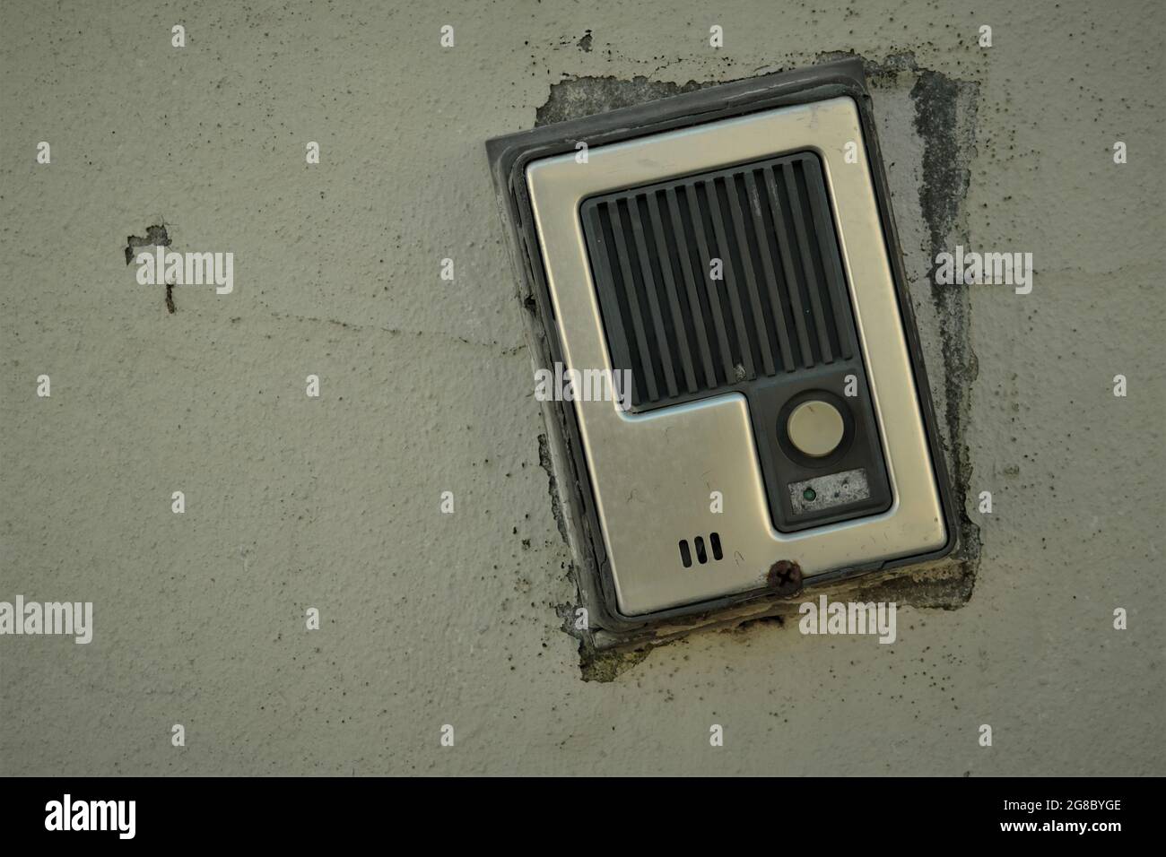 Un pannello di comunicazione intercom rotto su una parete sporca Foto Stock