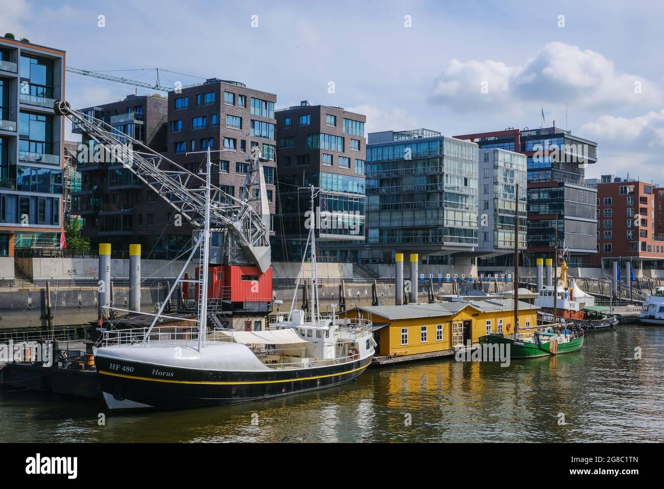 Amburgo, Germania - Hafenity, moderni edifici residenziali e uffici a Sandtorhafen, nel tradizionale porto navale con vecchia gru portuale. Foto Stock