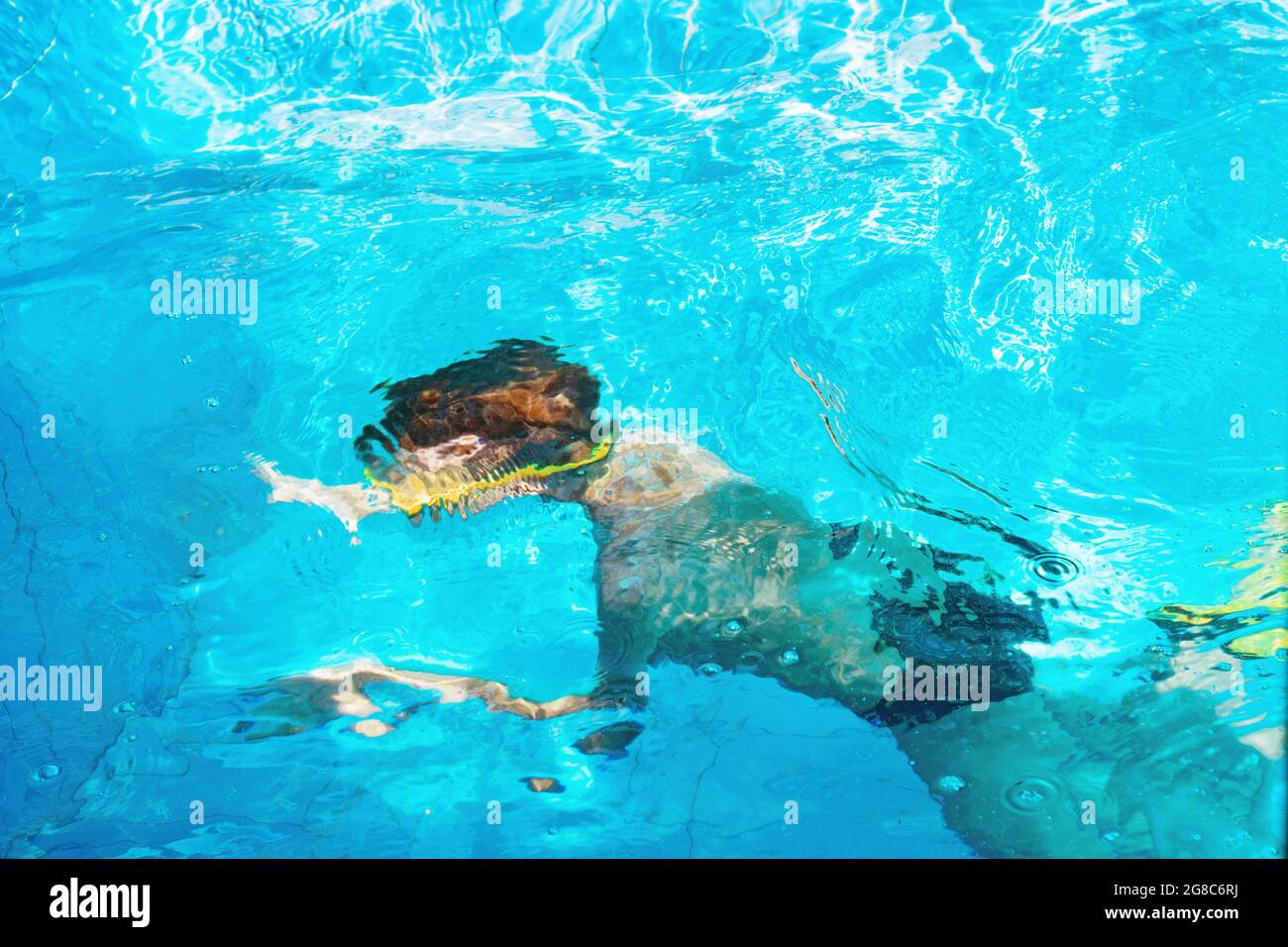 Il ragazzo nuota in piscina all'aperto con occhiali e pinne, Foto Stock