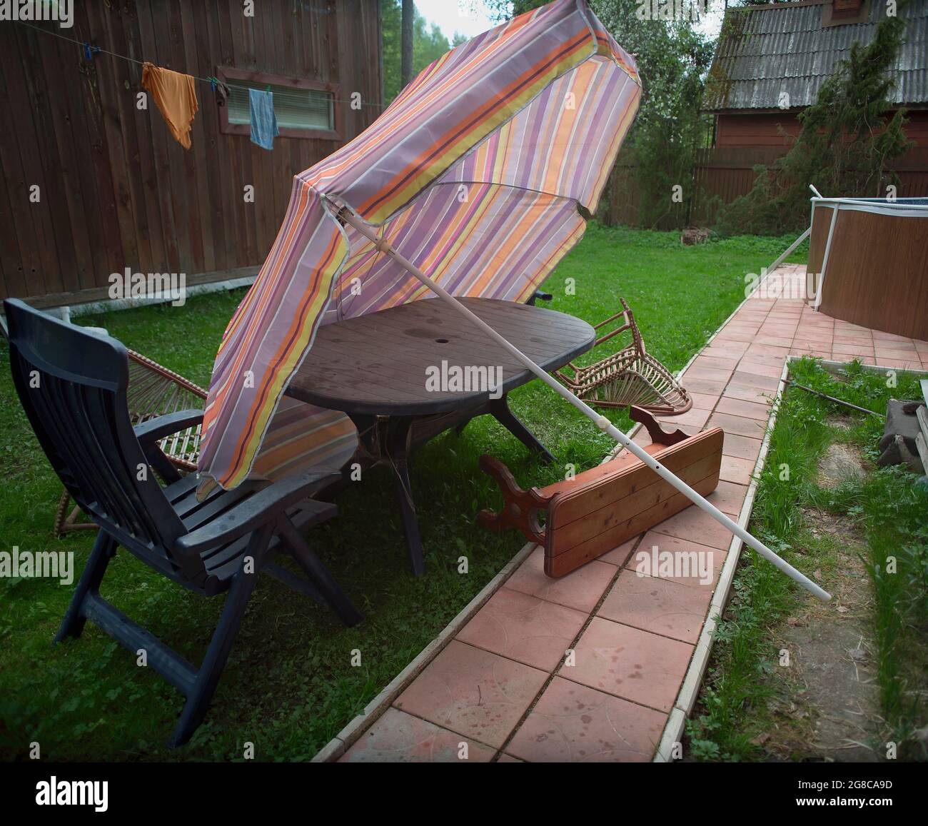 Mobili da giardino e ombrellone girati dopo la tempesta, colpo all'aperto  Foto stock - Alamy