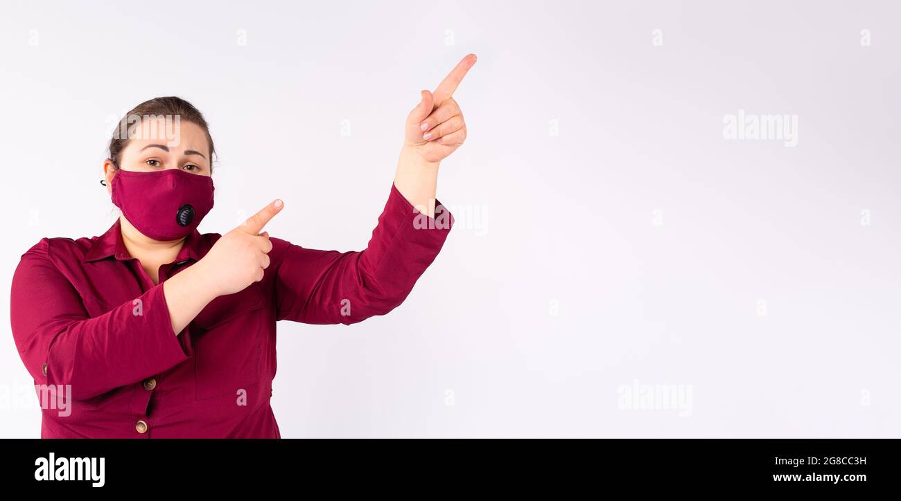 Modello di moda più taglia in abiti casual moda rosa indossare maschera di un colore rosa mostra mani in su. Foto Stock