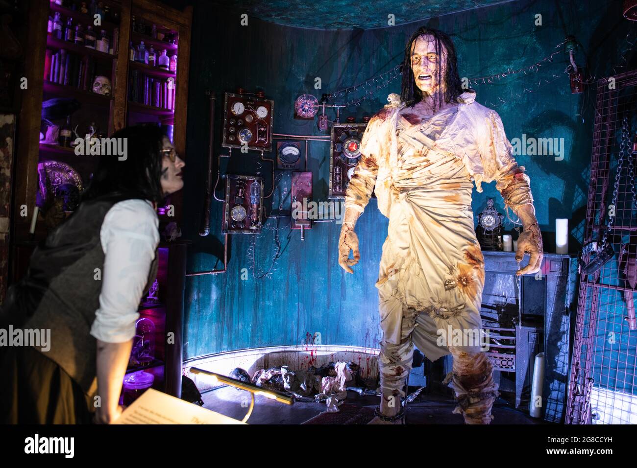 Bath, Regno Unito. 15 luglio 2021. Nella foto: Un membro del personale che indossa un costume d'epoca si inclina verso una ricreazione di otto piedi del mostro di Frankenstein. Foto Stock