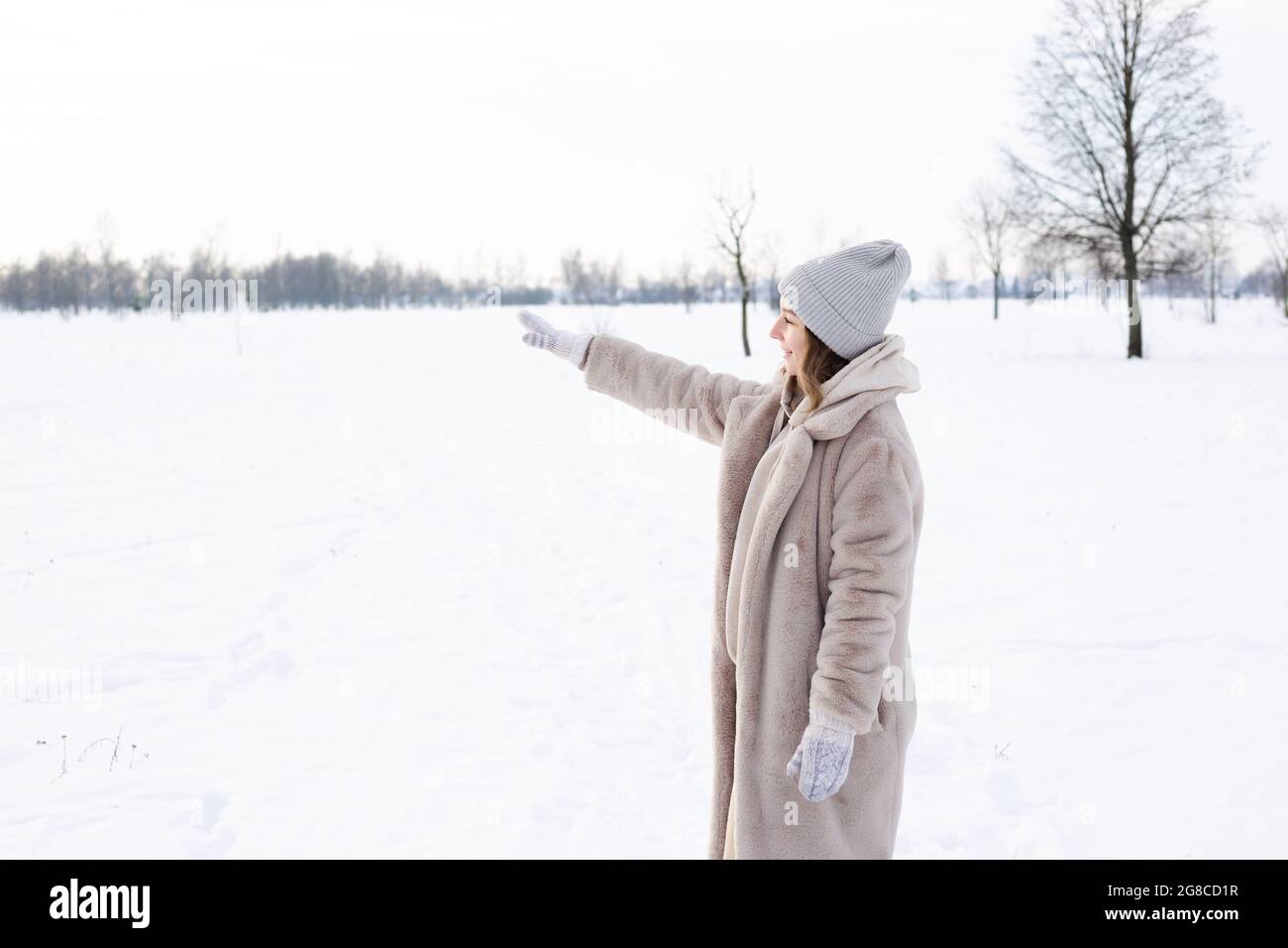 Giovane ragazza in abiti beige, cappotto di pelliccia artificiale passeggiate in inverno Foto Stock