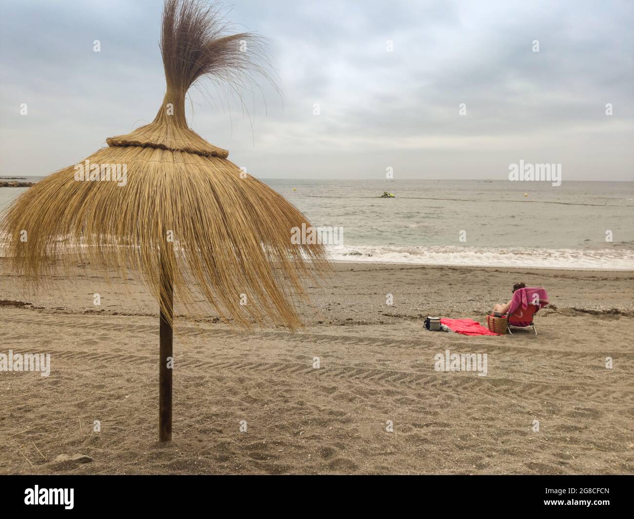 Ombrello hawaiano sulla spiaggia con una donna sullo sfondo Foto stock -  Alamy