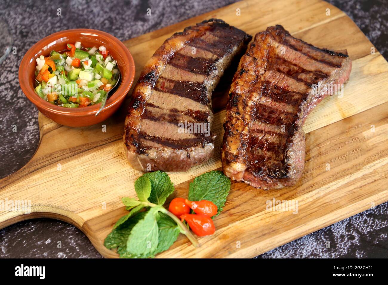 Picanha. Bistecca brasiliana alla griglia. Due fette di Picanha con salsa  verde, farofa, coltello, vinagrete. Cibo brasiliano Foto stock - Alamy