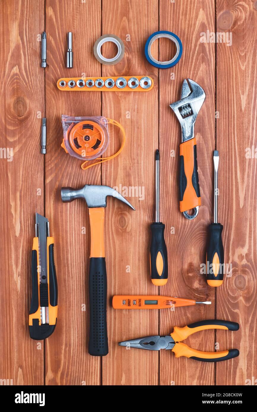 Set di utensili da costruzione su fondo di legno marrone. Martello, chiave, pinze e cacciavite. Biglietto d'auguri per la festa del lavoro, Festa del Padre. Foto Stock