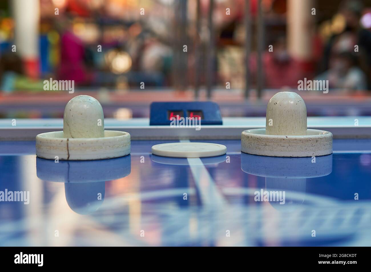 tavolo da hockey con disco e pagaie e tabellone segnapunti in una sala giochi. sfondo orizzontale e sfocato Foto Stock