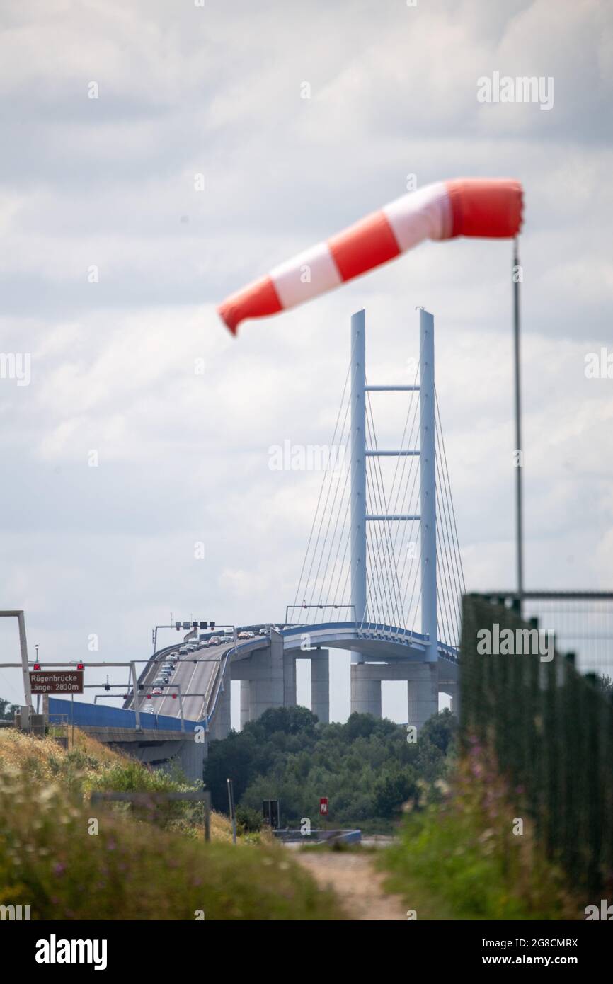 19 luglio 2021, Meclemburgo-Pomerania occidentale, Altefähr: Un ventoso è quasi orizzontale nell'aria, mostrando venti abbastanza forti.secondo l'Ufficio di Stato per la costruzione e i trasporti stradali, il ponte di Rügen ha avuto un fulmine che ha messo fuori servizio il sistema di controllo del traffico del moderno ponte di Rügen. Il ponte sospeso lungo 2.8 chilometri con il suo cospicuo traliccio può normalmente essere utilizzato come una singola corsia in entrambe le direzioni. Foto: Stefan Sauer/dpa Foto Stock