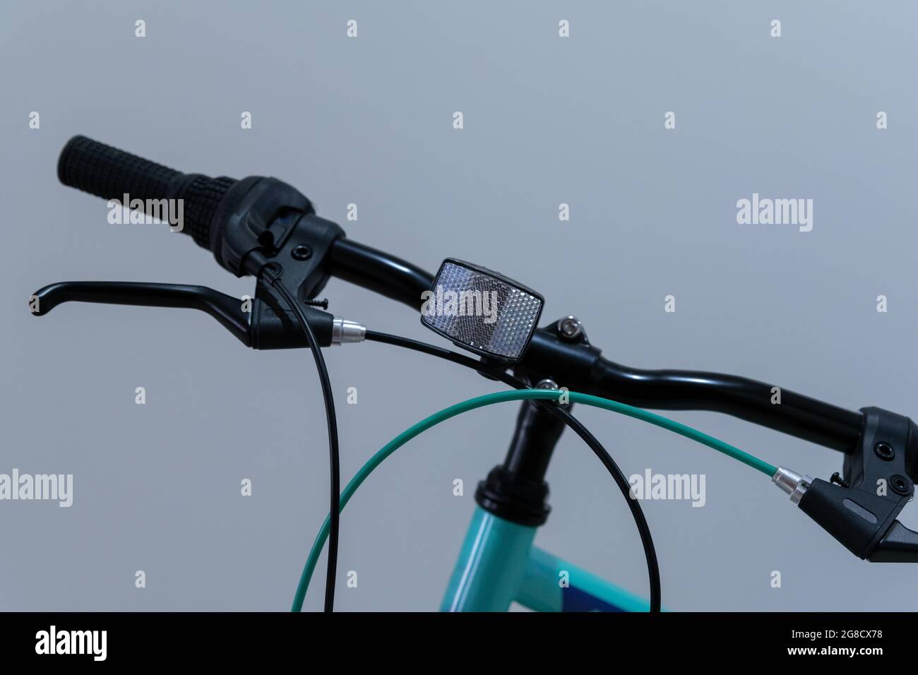 Fuoco selettivo sul riflettore bianco sul manubrio di una bicicletta per bambini Foto Stock