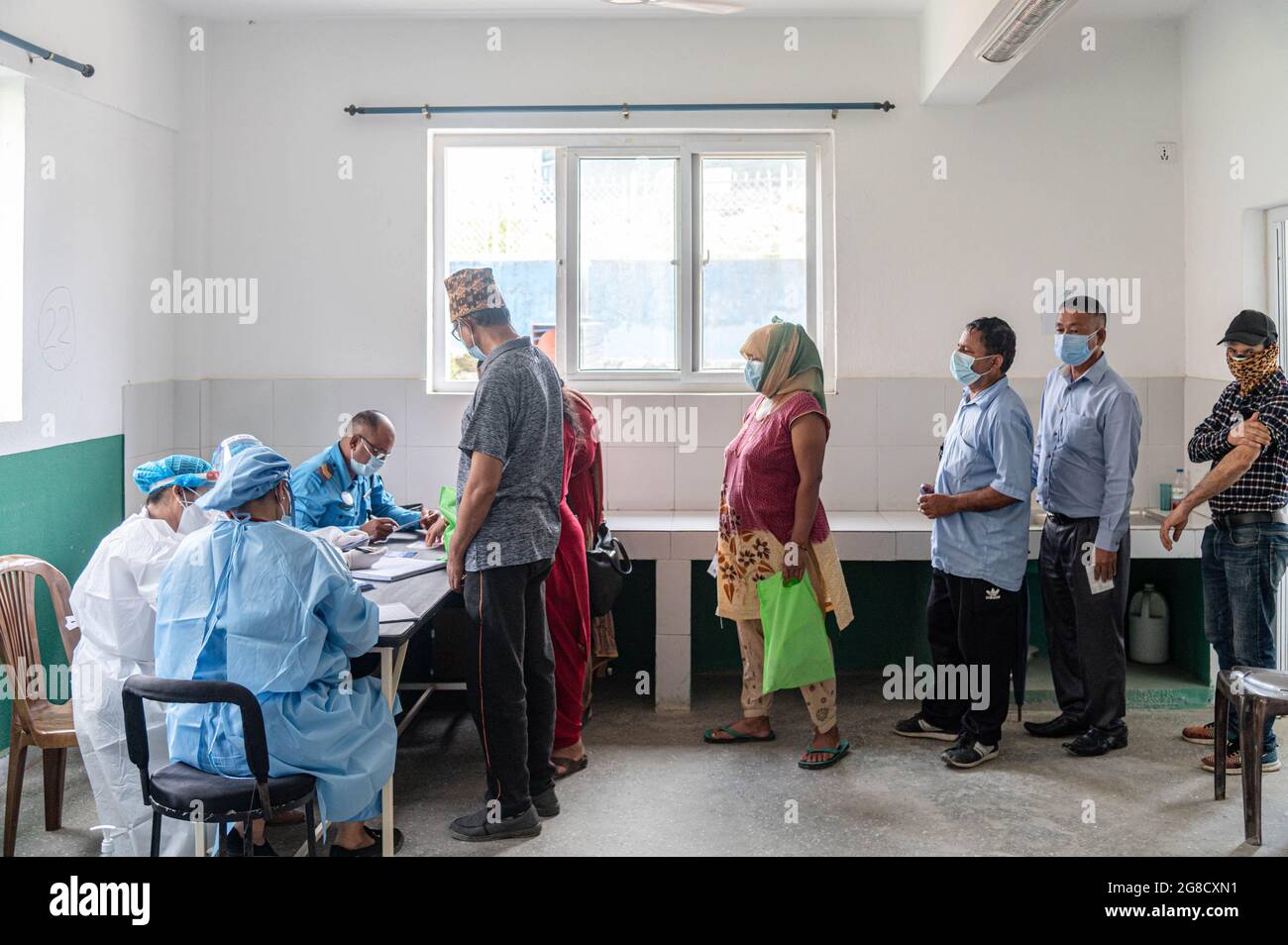 Persone in fila per la registrazione prima di prendere il jab di Janseen (American Covid-19 vaccino) presso l'ospedale comunale di Mulpani. Persone di età compresa tra 50-54 e 30 anni sono vaccinate fino al luglio 21, che comprende disabili, Lavoratori sanitari e stranieri migranti provenienti dal Nepal, dove questo vaccino americano viene approvato dal paese in questione. Il Nepal ha ricevuto 1.634 milioni di dosi di vaccino J & J dagli Stati Uniti il 12 luglio, attraverso COVAX, un programma internazionale di condivisione dei vaccini. (Foto di Dipendra Rokka/SOPA Images/Sipa USA) Foto Stock