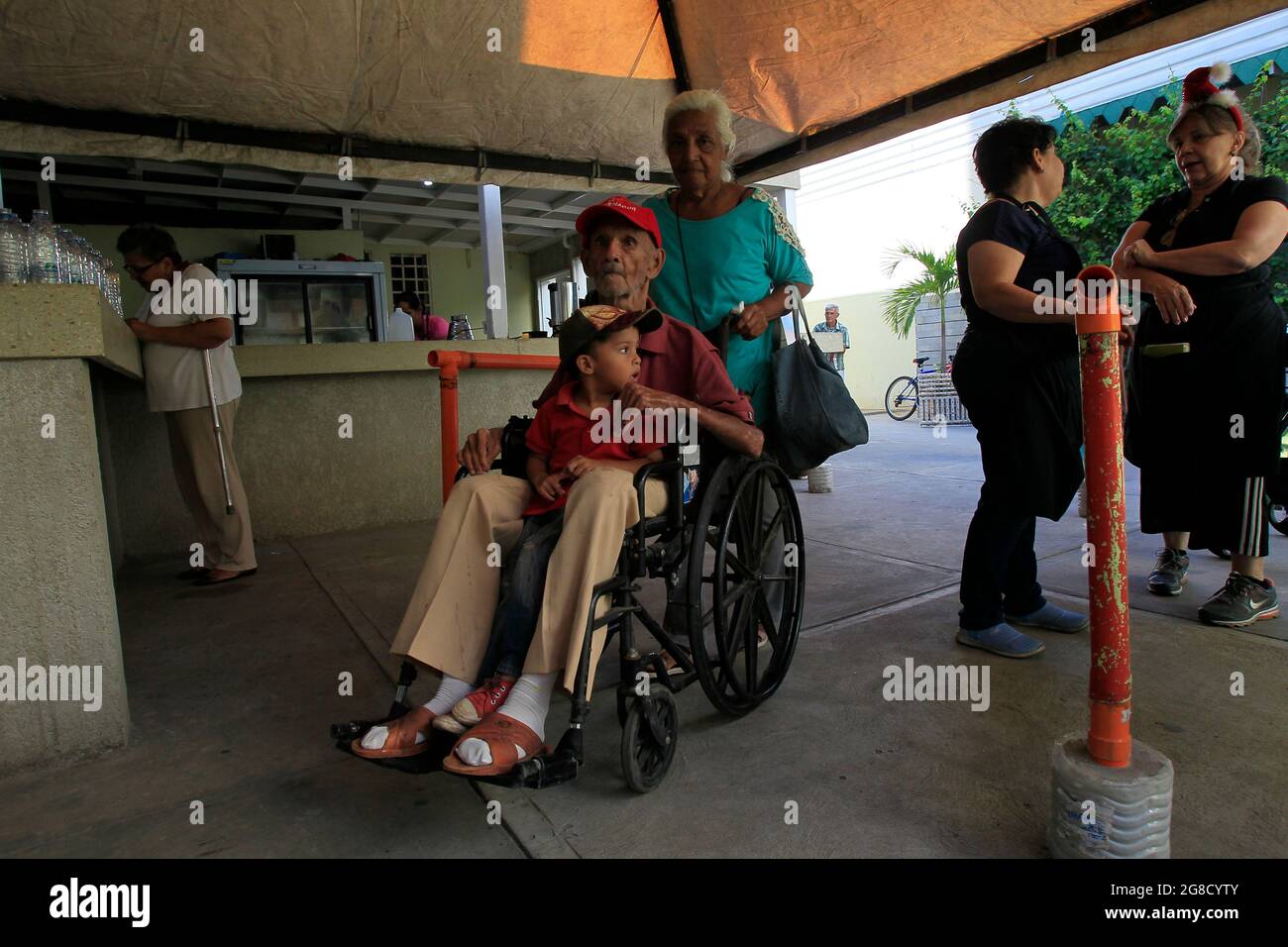 Maracaibo, Venezuela. Gli anziani disabili aspettano in un centro di beneficenza che offre loro pranzi. Foto di: José Bula Foto Stock