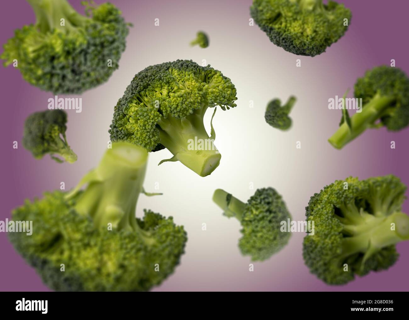 Il broccoli cade liberamente su sfondo colorato. Messa a fuoco selettiva - profondità di campo poco profonda. Cibo fresco. Foto Stock