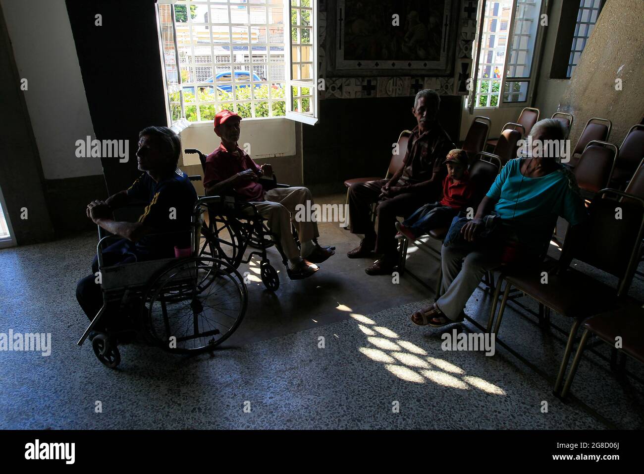 Maracaibo, Venezuela. Gli anziani disabili aspettano in un centro di beneficenza che offre loro pranzi. Foto di: José Bula Foto Stock