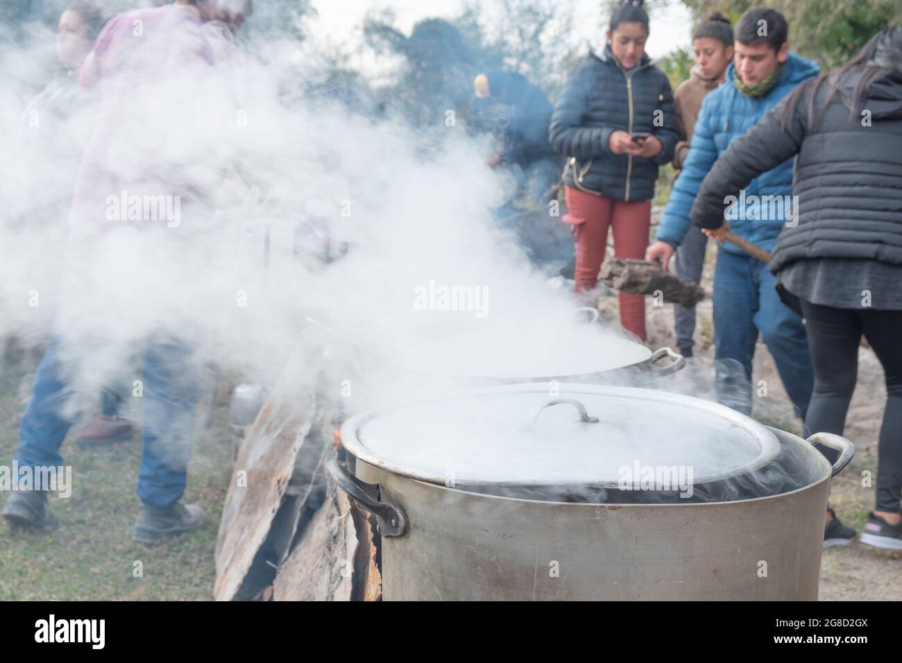 Volontari che servono cibo gratuito a umili persone senza casa nella cucina comunitaria Foto Stock