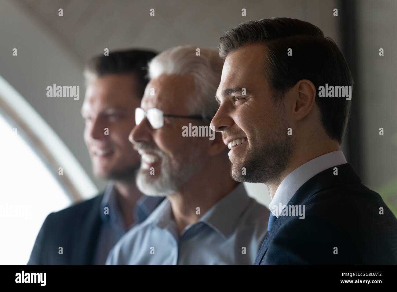 Felice giovane business leader maschile guardando via e sorridendo Foto Stock