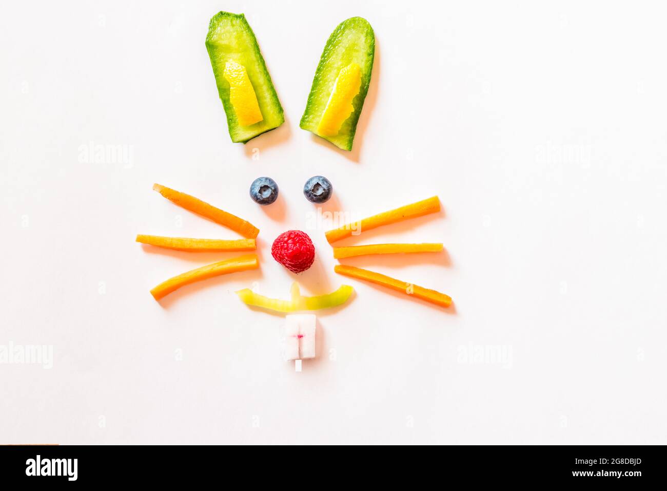 faccia di coniglio fatta da pezzi di frutta e verdura, isolata su sfondi bianchi Foto Stock