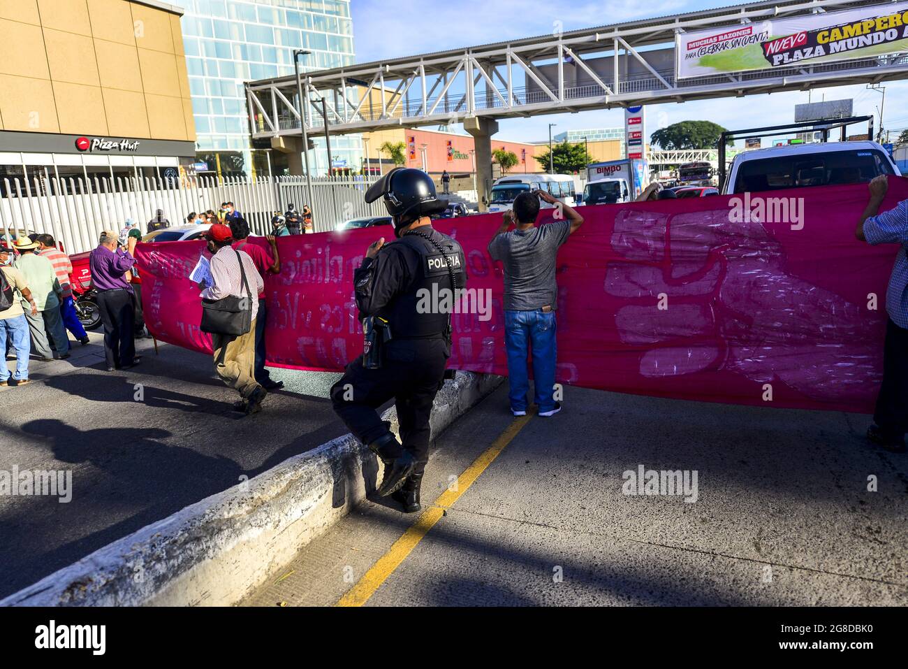 Apopa, El Salvador. 19 luglio 2021. Un ufficiale di polizia di un anti-sommossa cammina da veterani durante il blocco autostradale.i veterani della guerra hanno bloccato le principali autostrade di El Salvador per protestare contro l'intervento del governo nel lavoro autonomo del National Veterans Institute. Credit: SOPA Images Limited/Alamy Live News Foto Stock