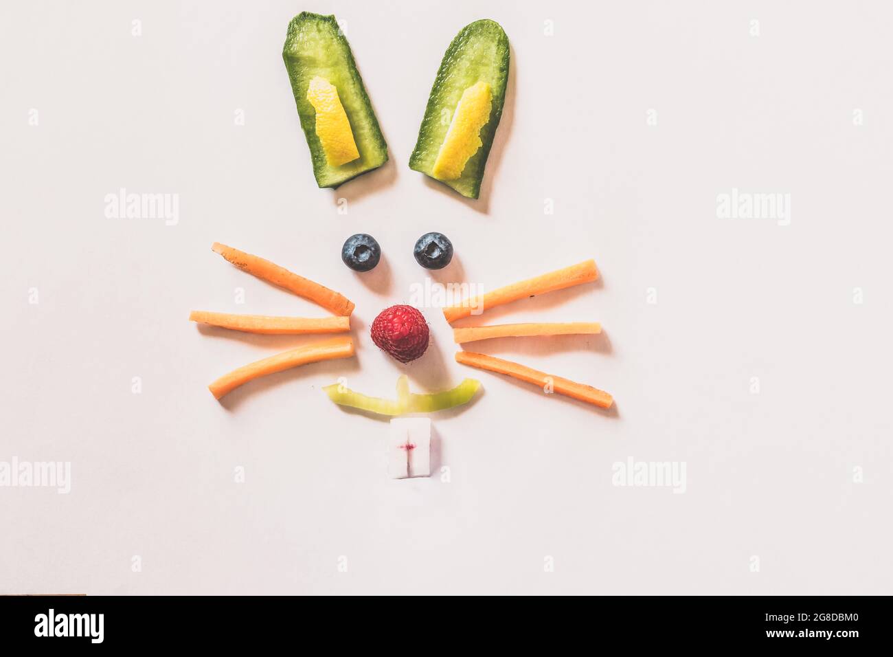 faccia di coniglio fatta da pezzi di frutta e verdura, isolata su sfondi bianchi Foto Stock