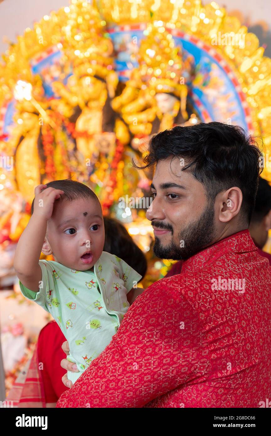 Kolkata, Bengala Occidentale, India - 6 ottobre 2019 : UN bel ragazzo si sta chiedendo mentre il padre lo tiene in su, Shobhabazar Rajbari , bonedi barhir pujo. Foto Stock