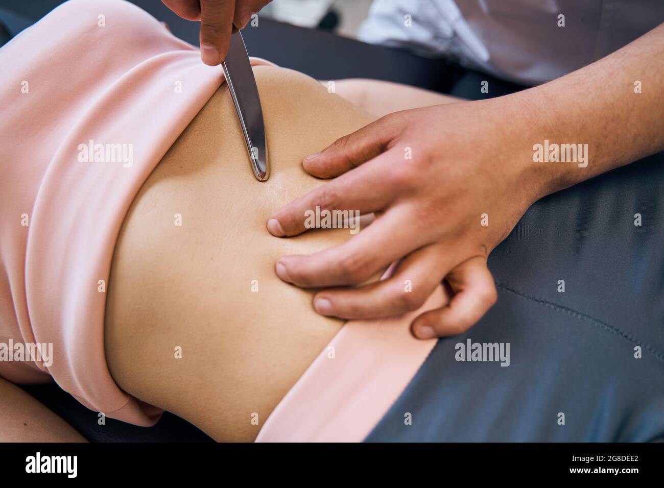 Fisioterapista controlla i muscoli addominali della donna sul letto di  massaggio. Sessione terapeutica di trattamento con IASTM Foto stock - Alamy