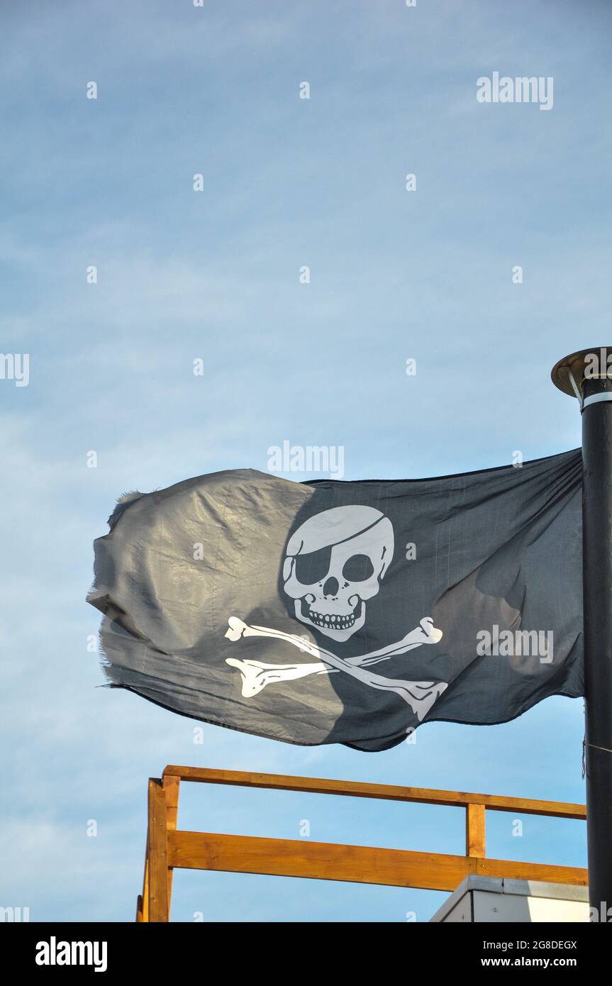 Bandiera nera dei pirati che oscilla nel vento Foto Stock