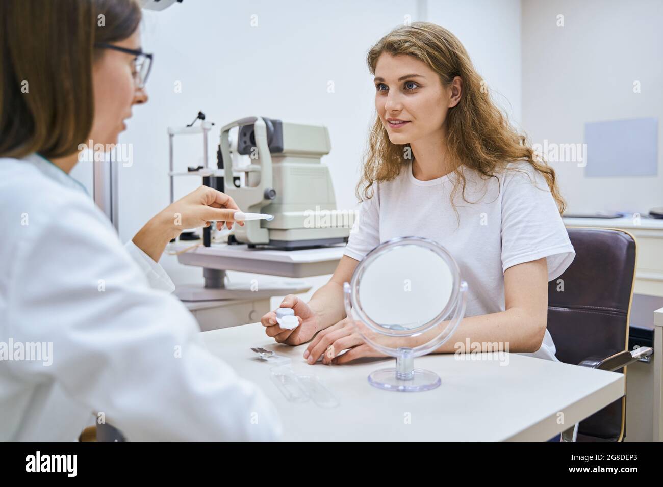 Bella giovane donna che ha consultazione con oculista in clinica Foto Stock