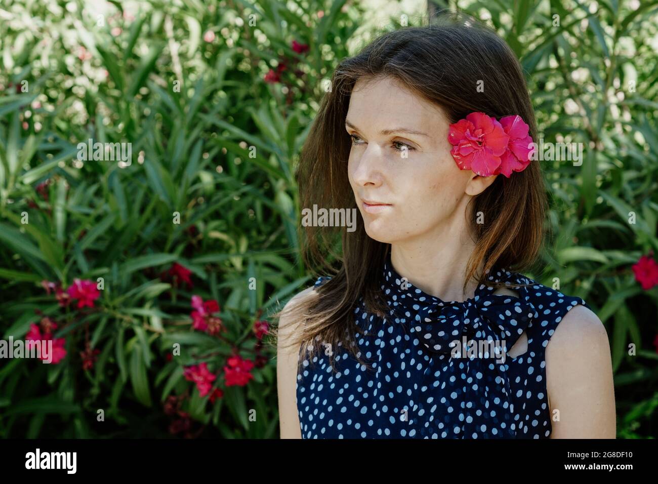 Bella signora spagnola con un fiore nei capelli è rilassante nel giardino panoramico Foto Stock