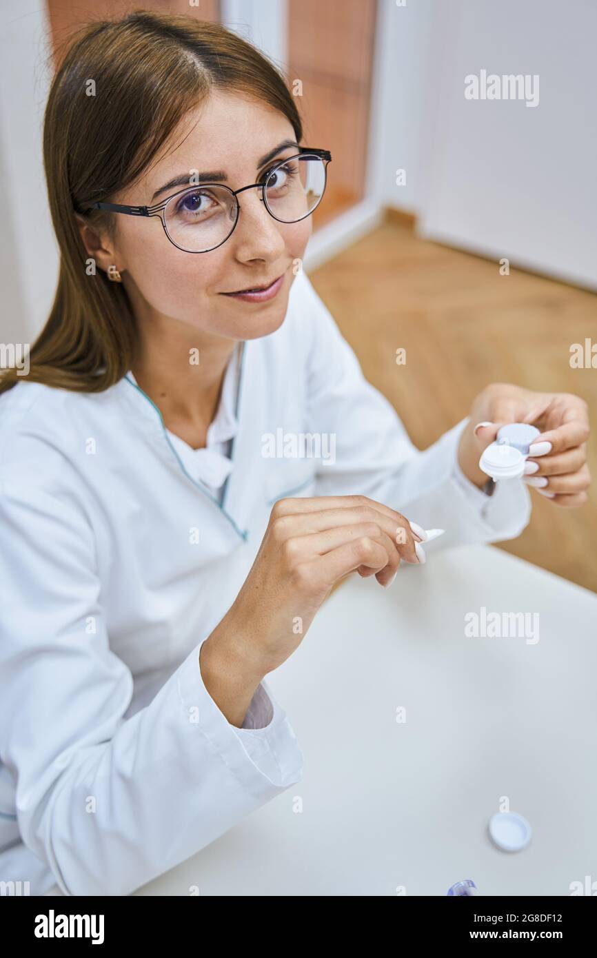 Giovane donna di charme oftalmologo che tiene lenti a contatto Foto Stock