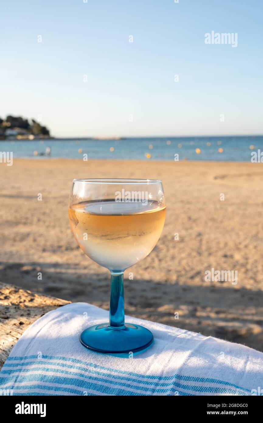 Estate in Provenza, bere di vino rosato secco freddo gris sulla spiaggia di sabbia e mare blu vicino Tolone, dipartimento del Var, Francia Foto Stock