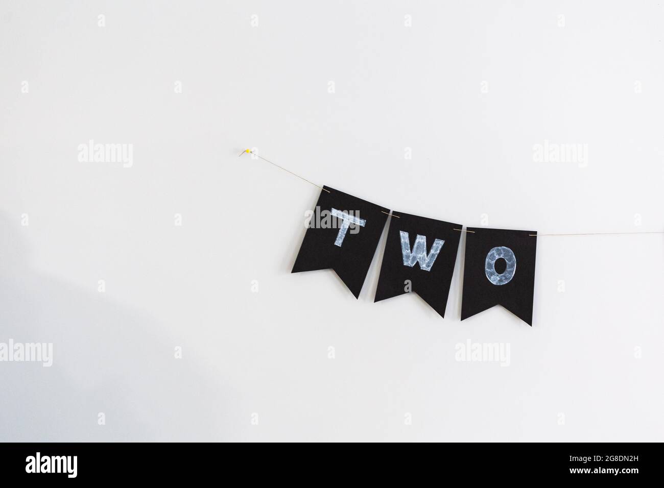 Due lettere decorazione di compleanno su bandiere nere su sfondo bianco Foto Stock