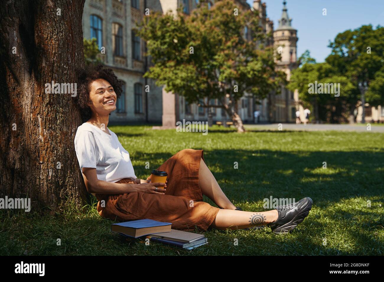 Donna che guarda felice mentre si rilassa nel parco Foto Stock