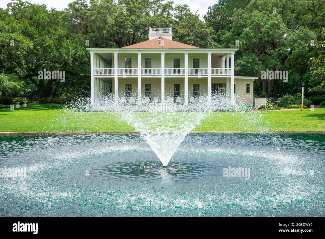 La fontana con laghetto a riflessione di fronte alla storica Wesley House nell'Eden Gardens state Park, Florida, USA Foto Stock