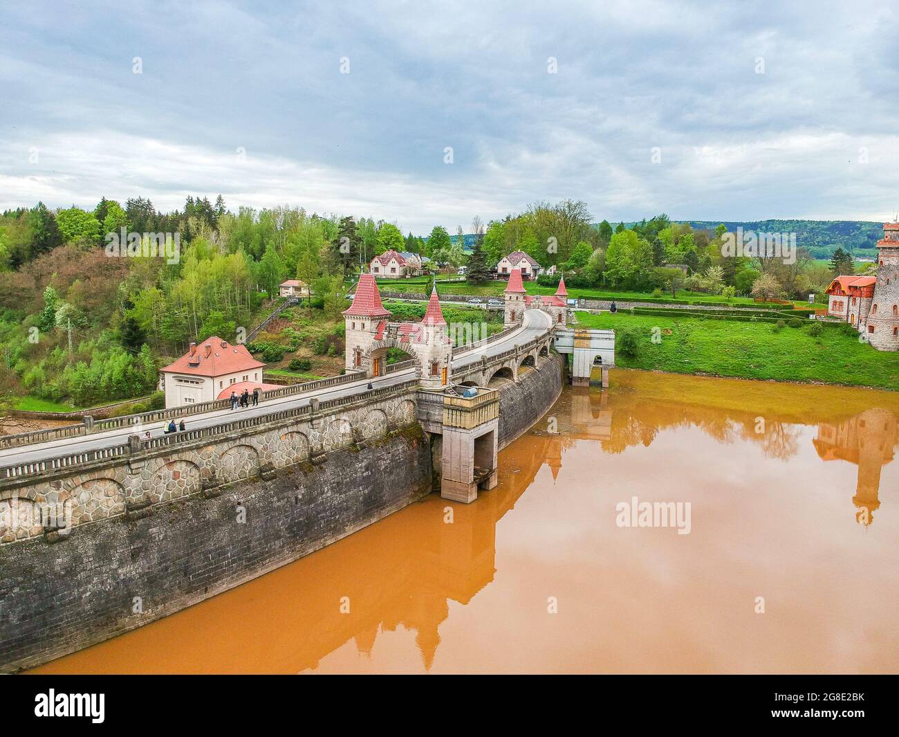 repubblica Ceca, Talsperre Les Kralovstvi (Regno della Foresta) - 15 maggio 2021. Vista aerea della storica diga idraulica con acqua arancione nel fiume Elba Foto Stock