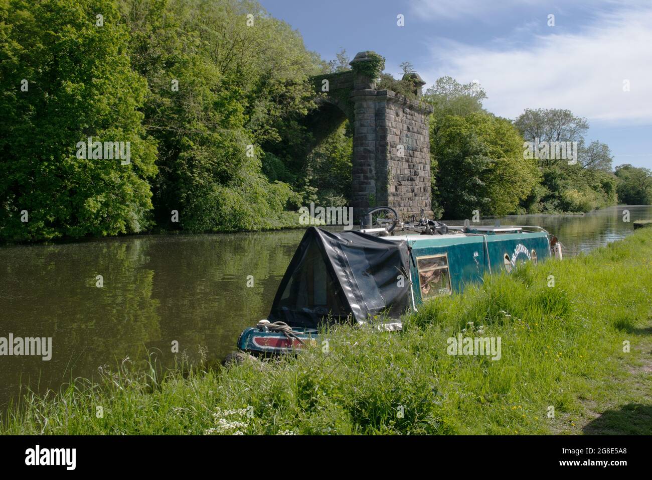 La stretta barca ormeggiata sul canale Gloucester e Sharpness accanto al vecchio ponte ferroviario Severn. Foto Stock