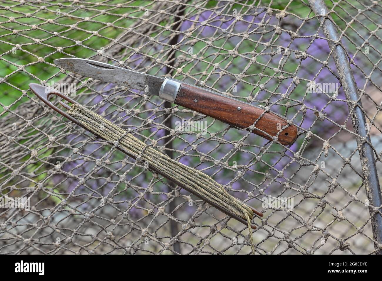 PRODUZIONE - 08 luglio 2021, Brandenburg, Brieskow-Finkenheerd: Gli attrezzi per riparare la rete di una trappola di pesci sono visti nel cantiere del pescatore maestro Peter Schneider. I deficit di precipitazioni degli ultimi anni hanno causato la caduta dei livelli d'acqua in numerosi laghi e fiumi del Marco Brandeburgo. "Non è una minaccia immediata per la fauna ittica là finché il corpo d'acqua non si è effettivamente prosciugato", ha detto Dettmann, direttore esecutivo dell'associazione di pesca statale del Brandeburgo. Con il clima che si alterna tra calore e siccità e poi pioggia localmente pesante, almeno le cose stanno lavorando fuori Foto Stock