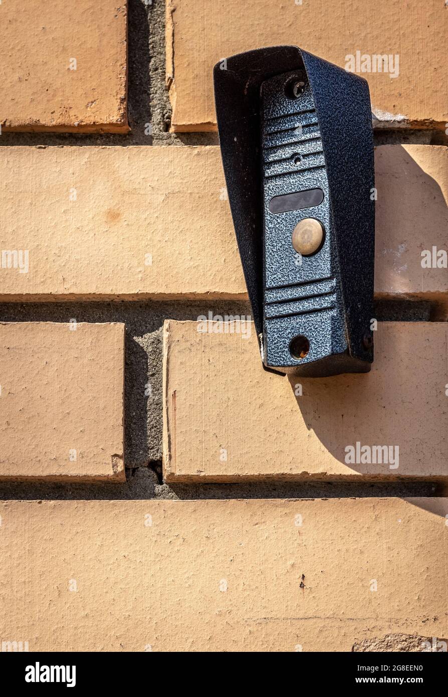 La parte esterna del citofono sul muro di mattoni della recinzione vicino all'ingresso della casa privata. Foto Stock