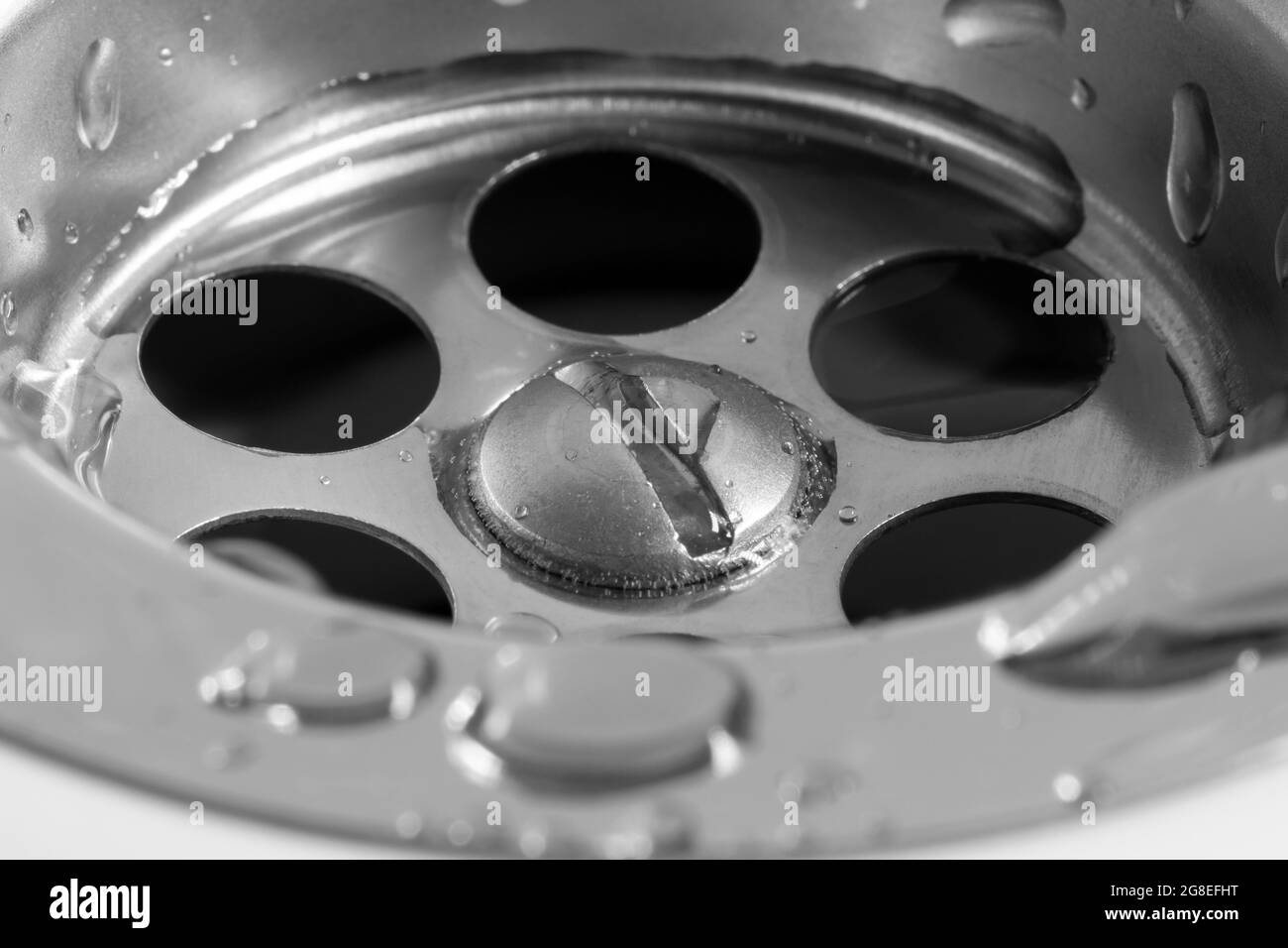 Primo piano di un foro di scarico in un lavello in ceramica bianca. Foto Stock