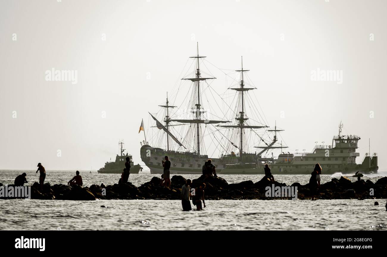 Silhoutte di turisti nel Golfo Finlandese, ricostruita nave-pistola Poltava in background, Parco del 300 ° anniversario di San Pietroburgo, Russia Foto Stock