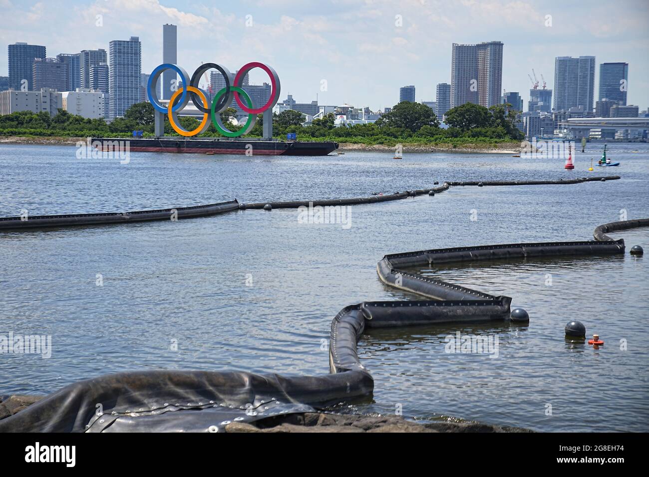 Tokio, Giappone. 20 luglio 2021. Le barriere si trovano sull'acqua per ridurre l'inquinamento nella Baia di Tokyo. Sullo sfondo c'è un pontile con anelli olimpici. Le Olimpiadi di Tokyo 2020 si terranno dal 23.07.2021 al 08.08.2021. Credit: Michael Kappeler/dpa/Alamy Live News Foto Stock