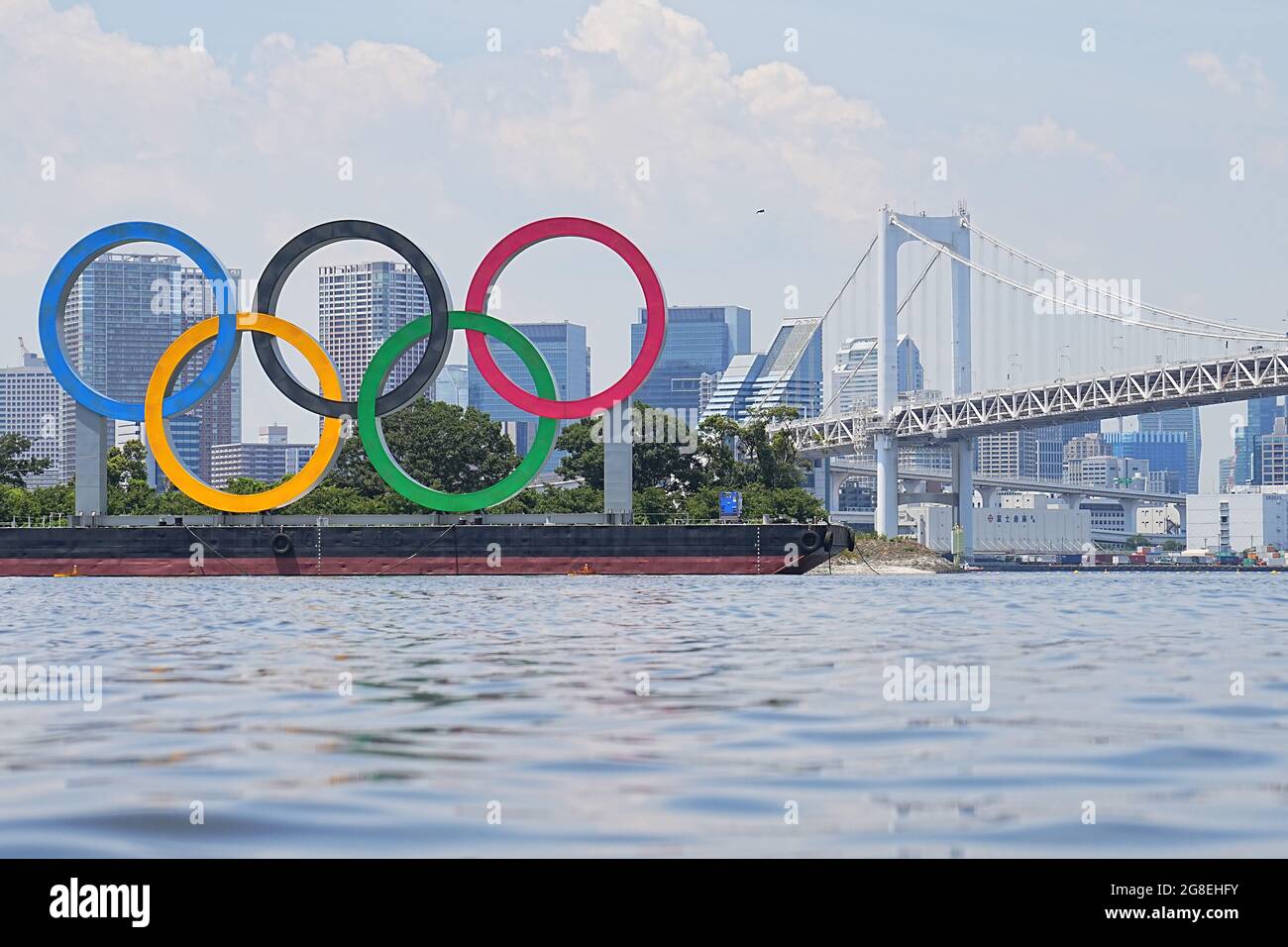 Tokio, Giappone. 20 luglio 2021. Una vista degli anelli Olimpici di fronte al Ponte dell'Arcobaleno. Gli anelli si ergono su un pontile nella Baia di Tokyo. Le Olimpiadi di Tokyo 2020 si terranno dal 23.07.2021 al 08.08.2021. Credit: Michael Kappeler/dpa/Alamy Live News Foto Stock