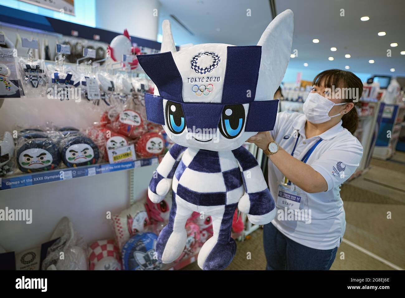 Tokio, Giappone. 20 luglio 2021. Una donna di vendita tiene in mano una figurina di stoffa della mascotte olimpica Miraitova in un negozio di fan dei Giochi Olimpici. Le Olimpiadi di Tokyo 2020 si terranno dal 23.07.2021 al 08.08.2021. Credit: Michael Kappeler/dpa/Alamy Live News Foto Stock