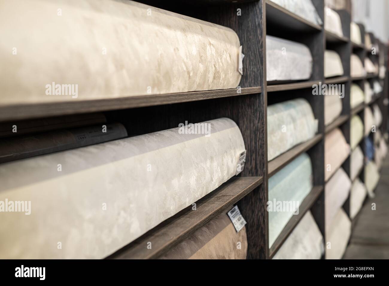 Scaffali con carta da parati arrotolata in un grande negozio di ferramenta Foto Stock