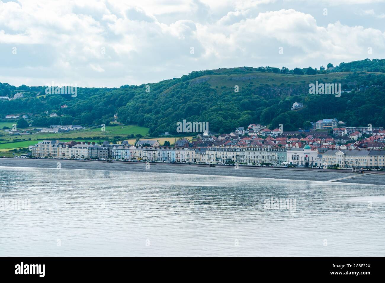 LLANDUDNO, GALLES - 04 LUGLIO 2021: Vista della curva passeggiata di Llandudno fiancheggiata dagli hotel. Foto Stock