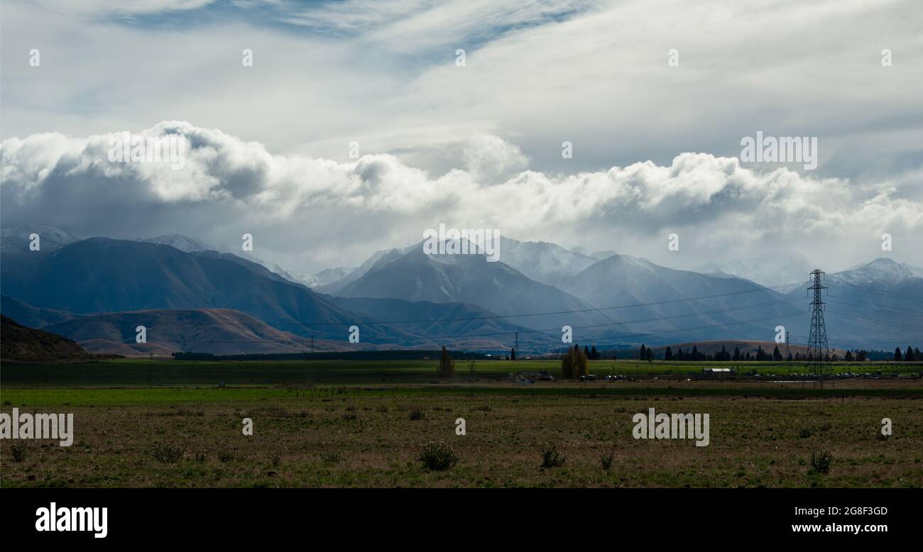 Vista panoramica della gamma ben Ohau con torri di trasmissione ad alta tensione e linee elettriche in primo piano, Twizel, Isola del Sud della Nuova Zelanda Foto Stock